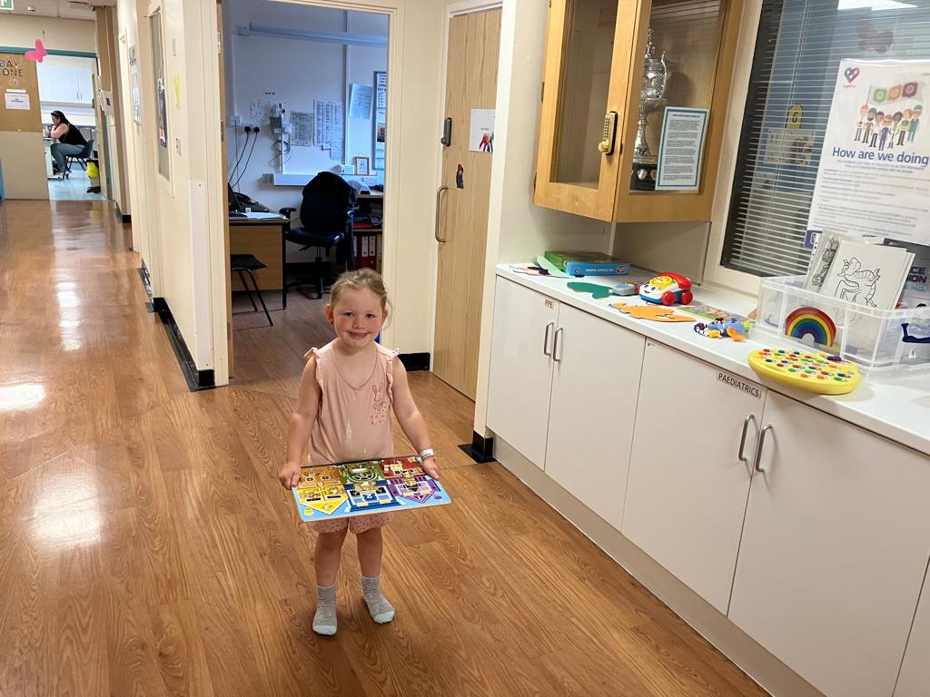 Child holding toys in a hospital setting