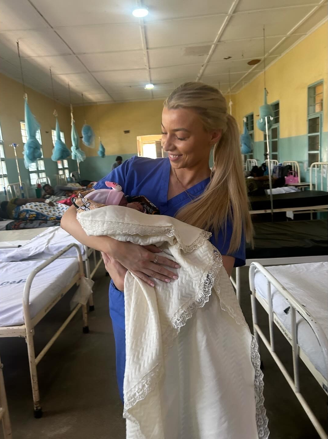 Bethany holding a baby in a medical setting