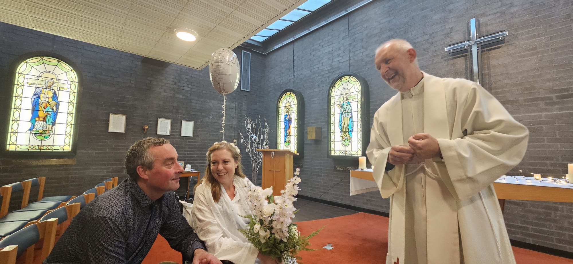 Photo of married couple next to the smiling chaplain