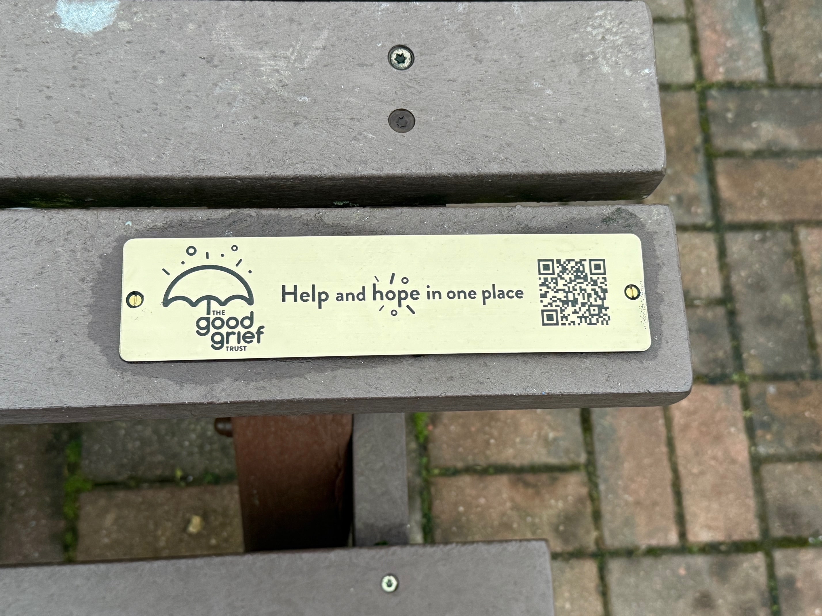 Photo of plaque on bench of wooden table