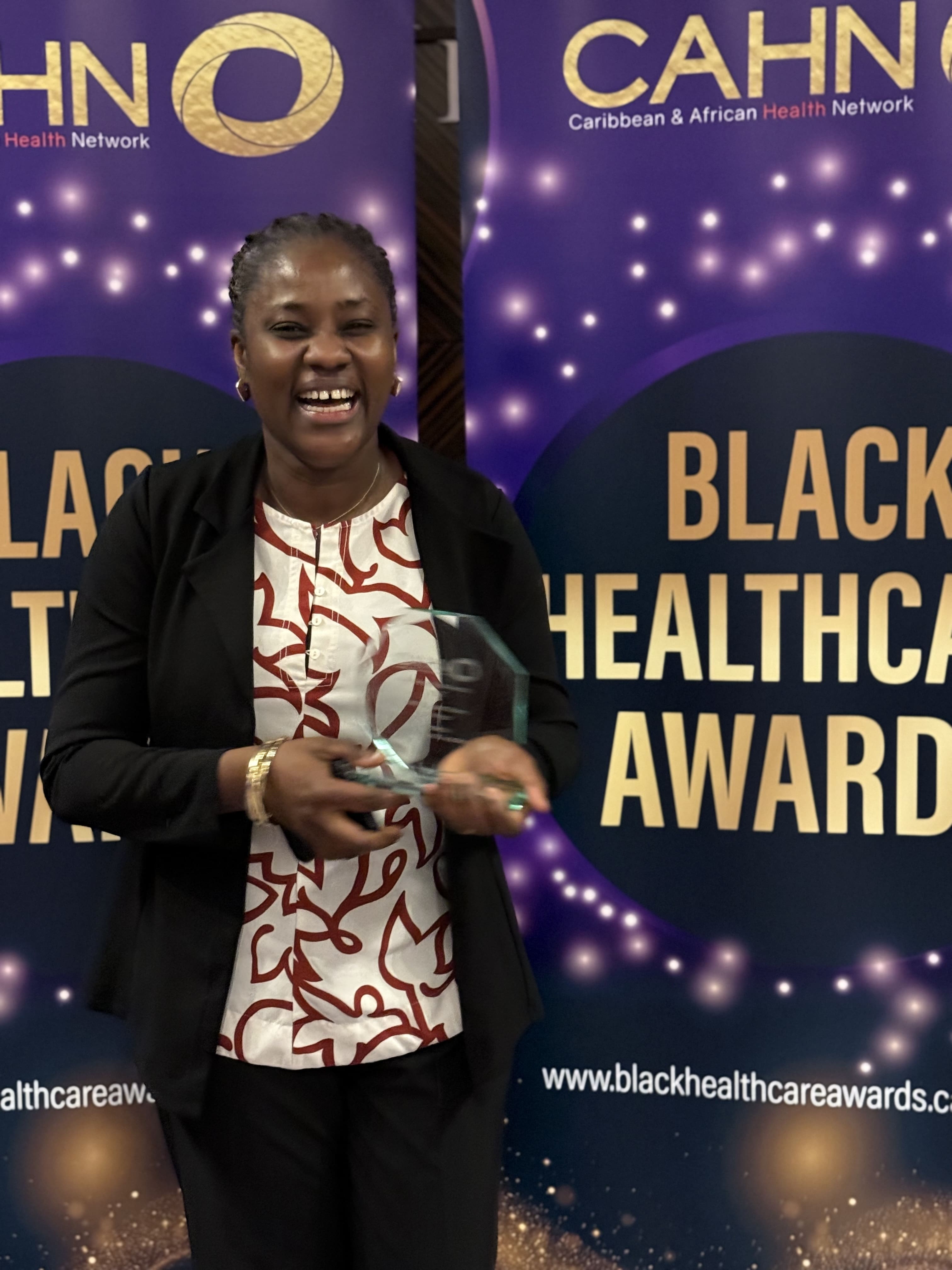 Photo of a smiling Oluchi, holding her award during a formal ceremony