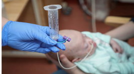 A photo depicting a baby having a tube-feed